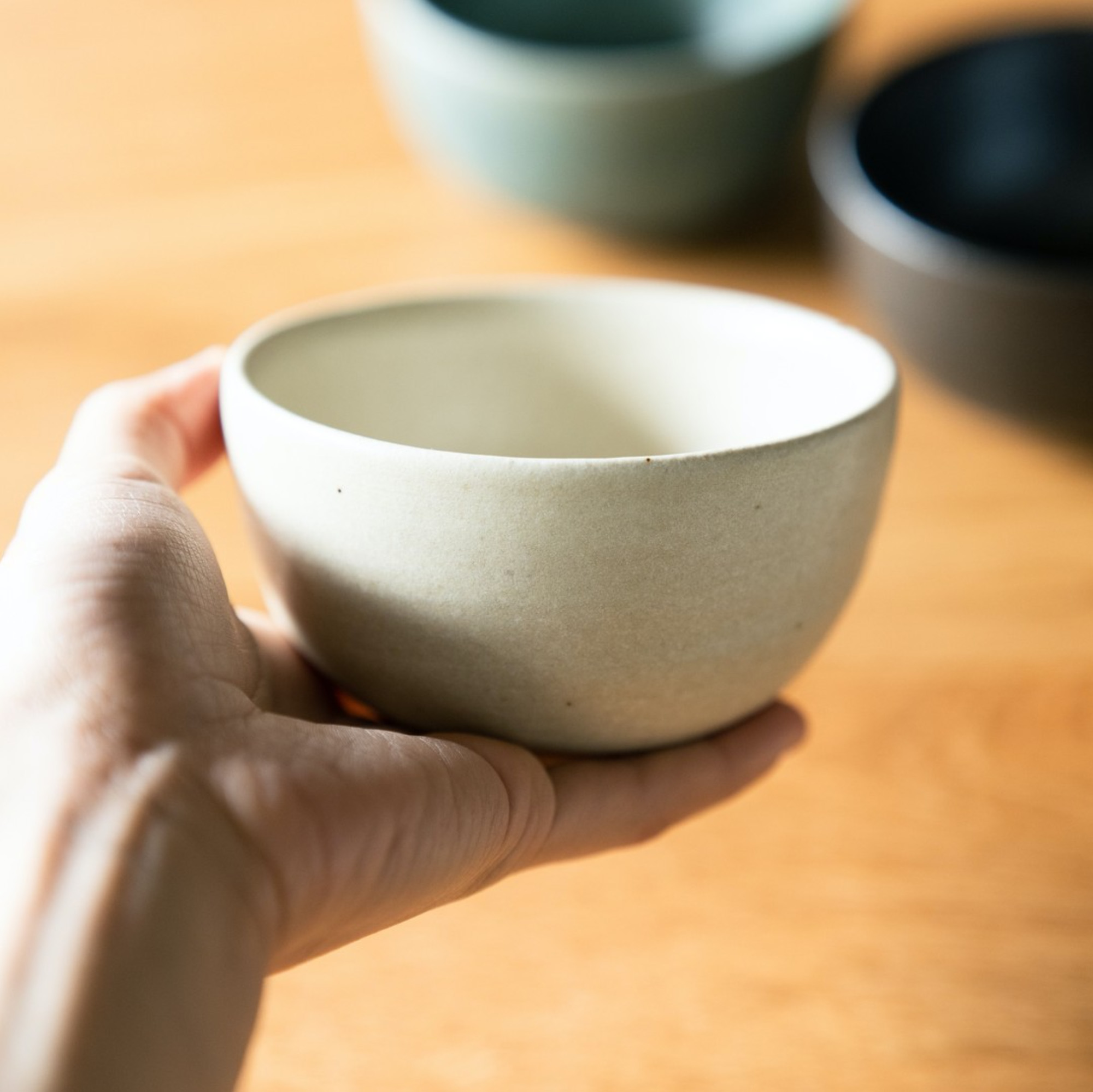 陶器の器を手に持っている