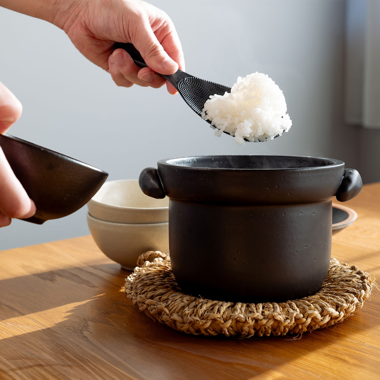 ごはん土鍋で作った炊き立てのご飯をお茶碗によそう様子