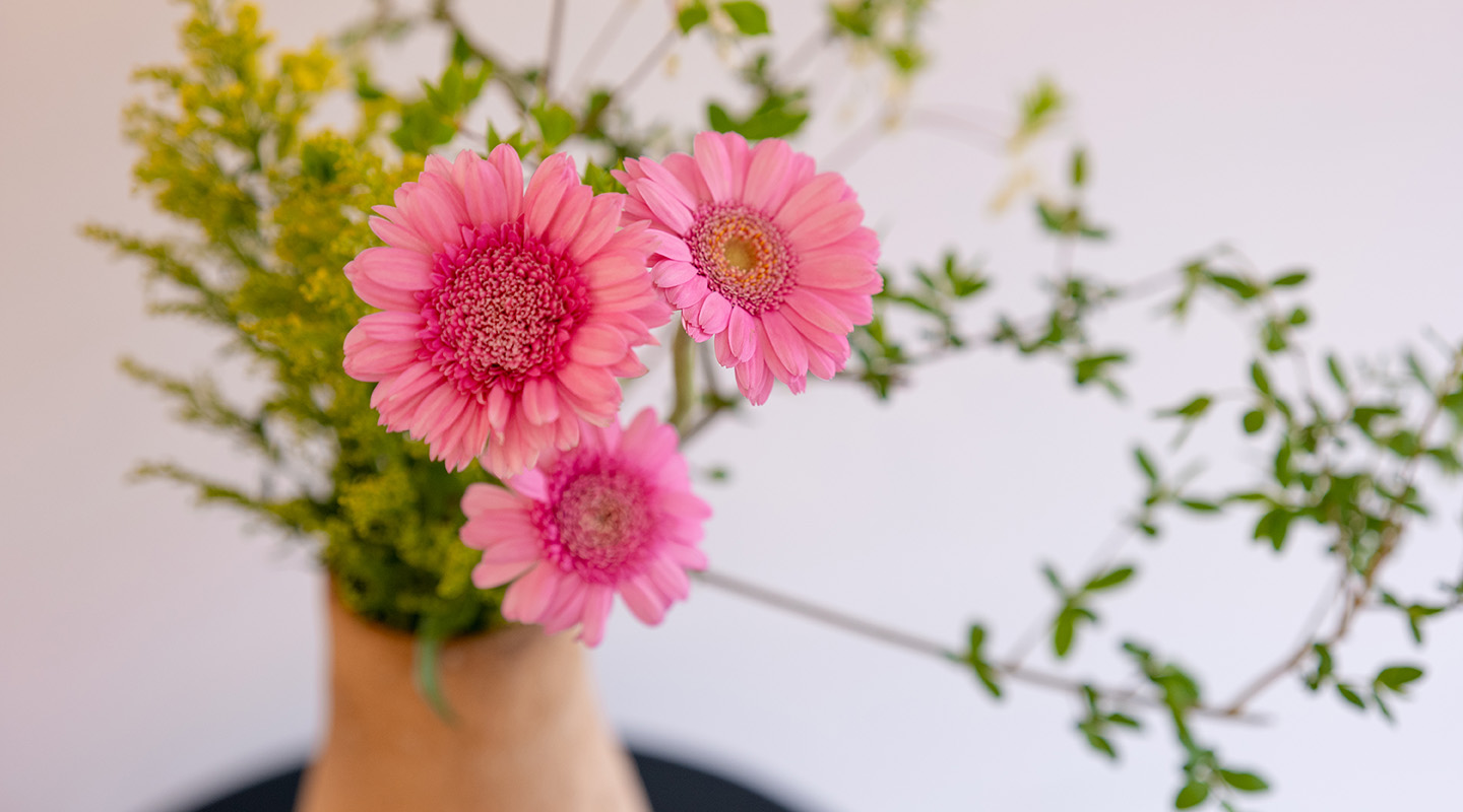 信楽焼の陶器の花器に生けられた鮮やかな花