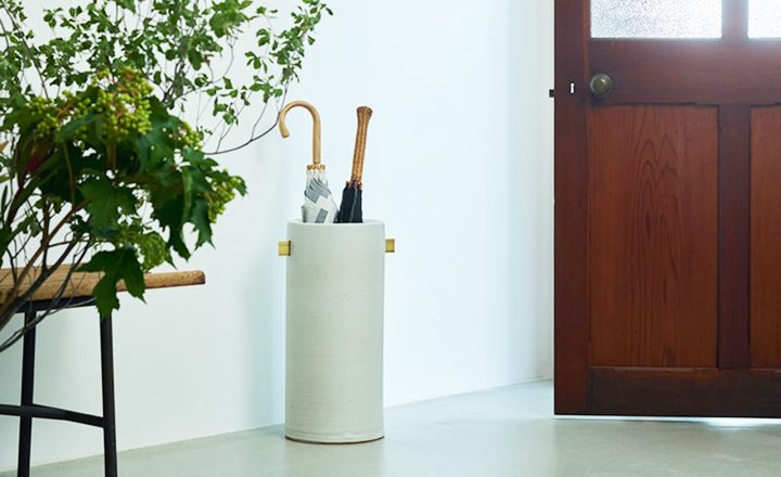 陶器のシンプルな傘立てに傘を収納している