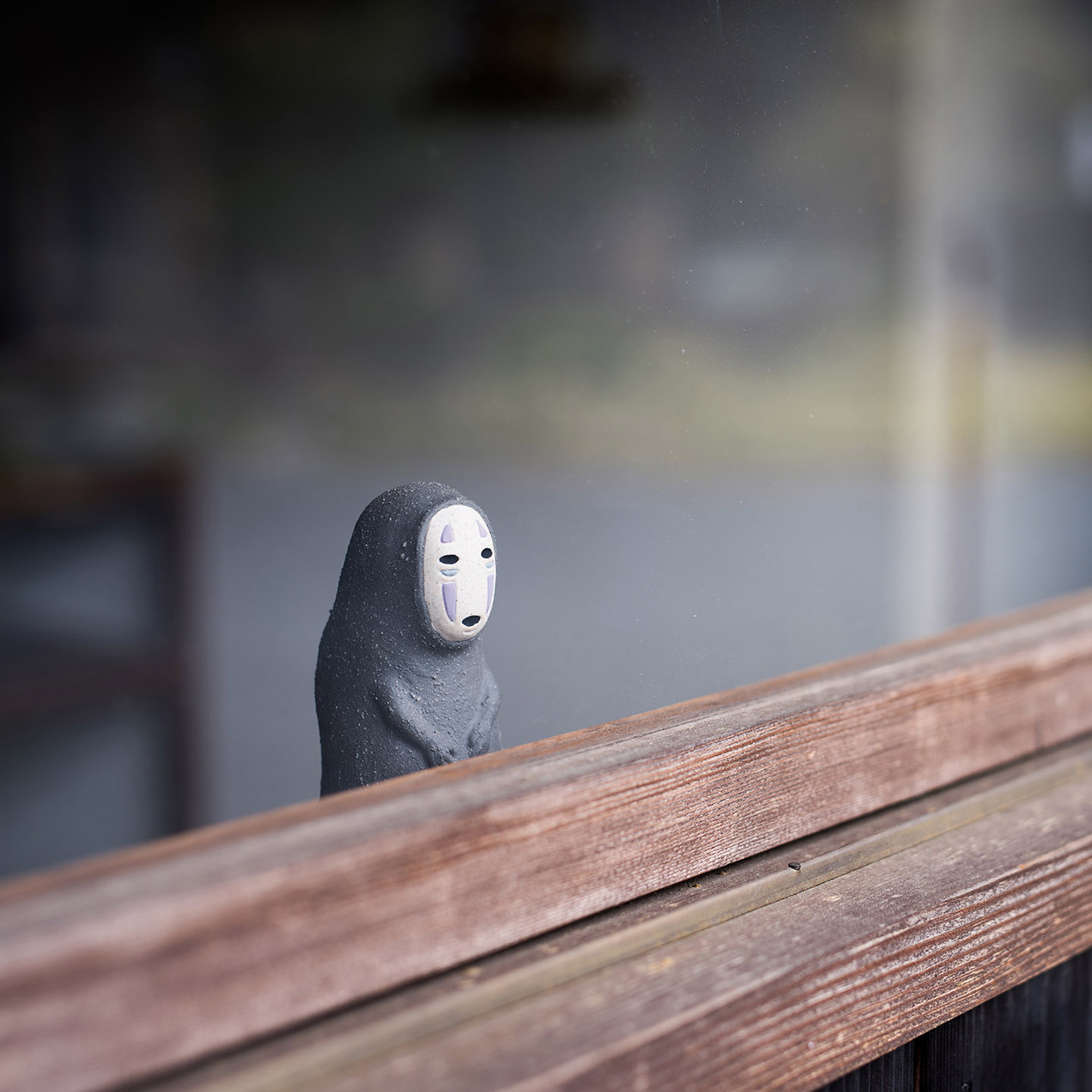 信楽焼のカオナシが窓越しにこちらを見つめている