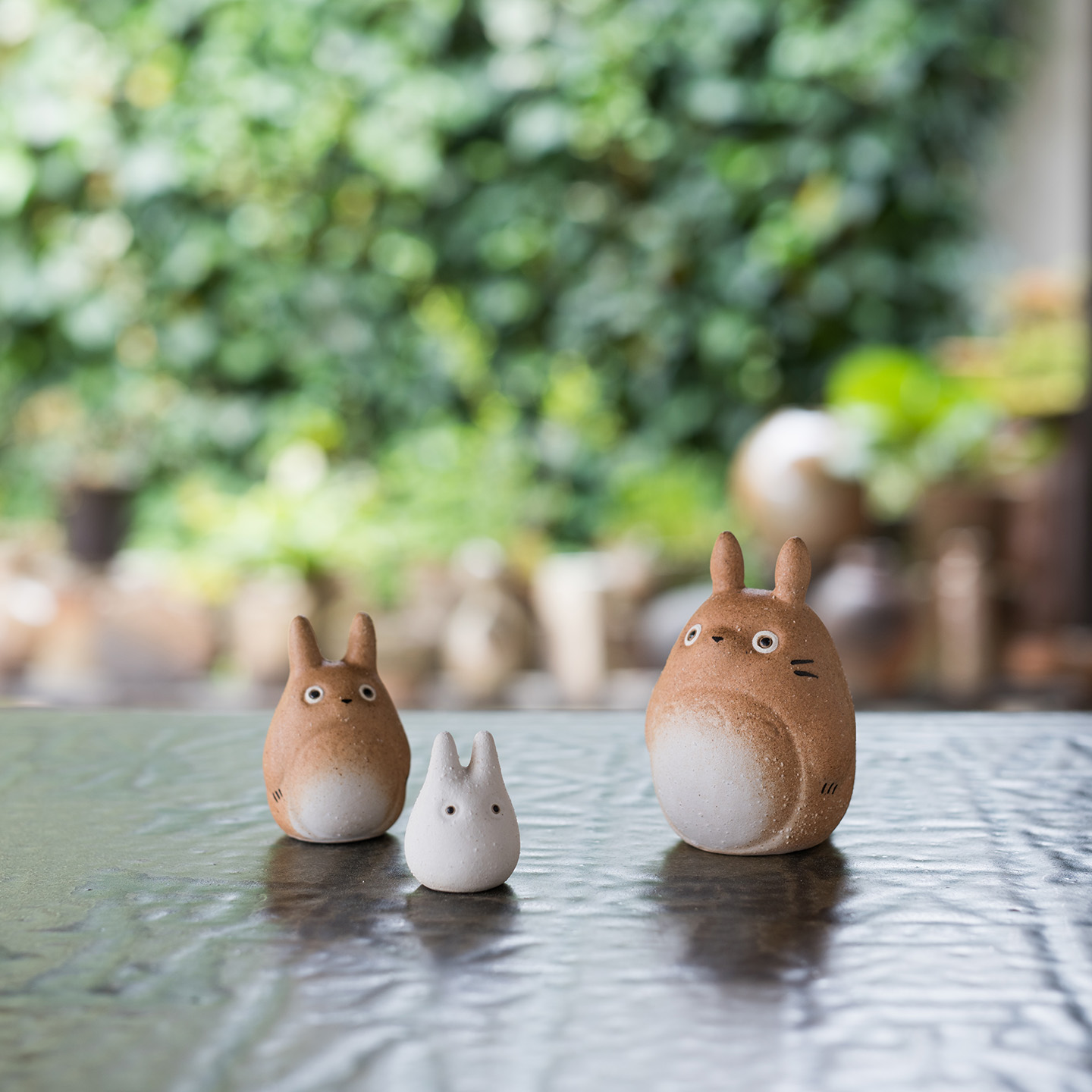 信楽焼 トトロの3体セット（大・中・小）の置物、自然の中で佇む姿