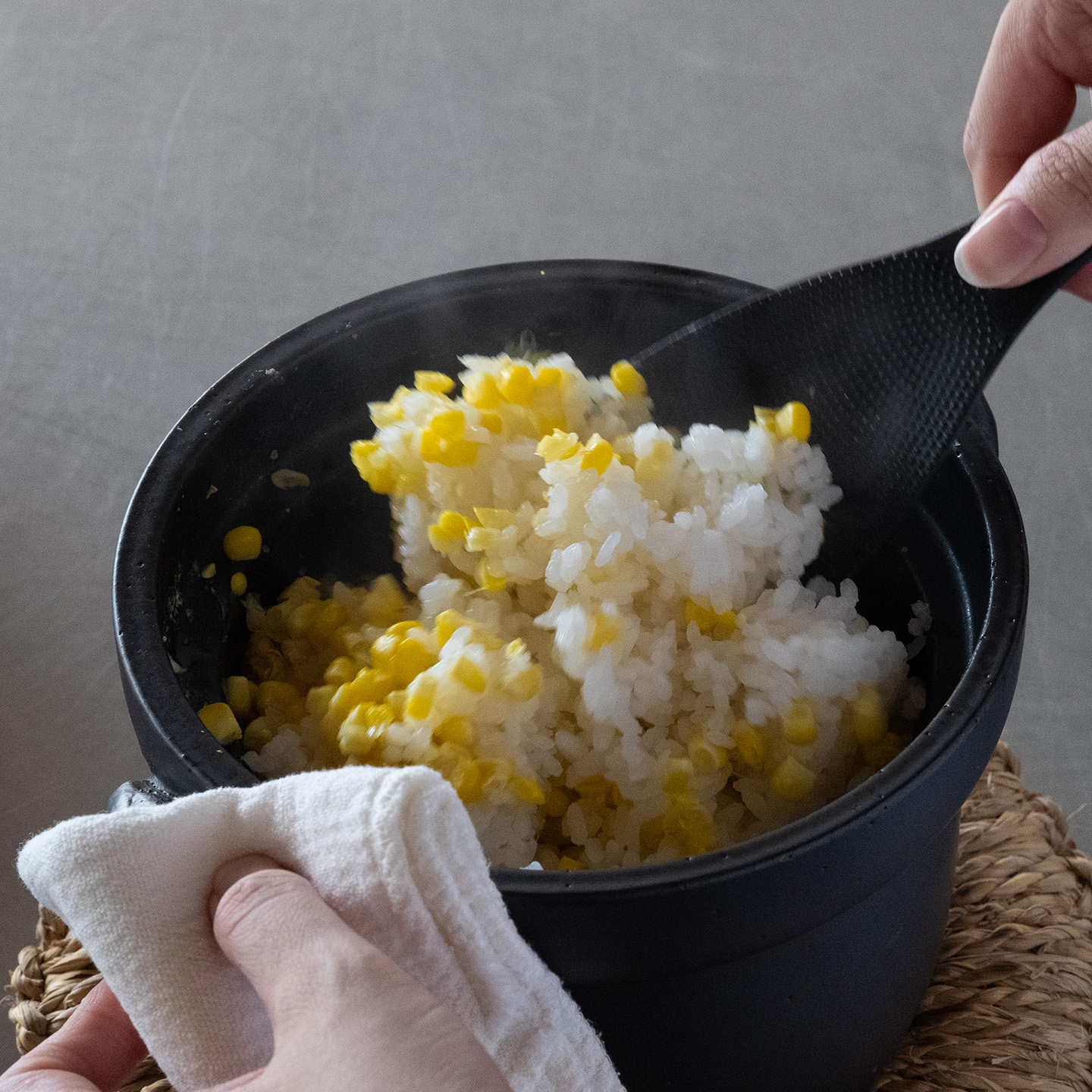 土鍋の中でとうもろこしご飯をふんわりと混ぜているところ