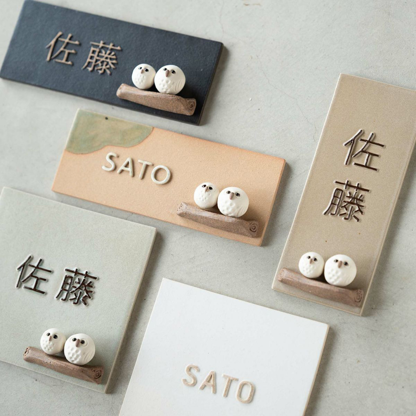 信楽焼の陶器表札にちょこんと乗ったしろちびふくろうが愛らしい、名前入りデザインの玄関表札