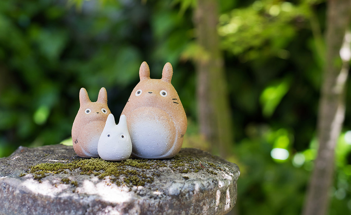 木台に飾られた信楽焼 トトロの3体セットと緑の枝のコーディネート