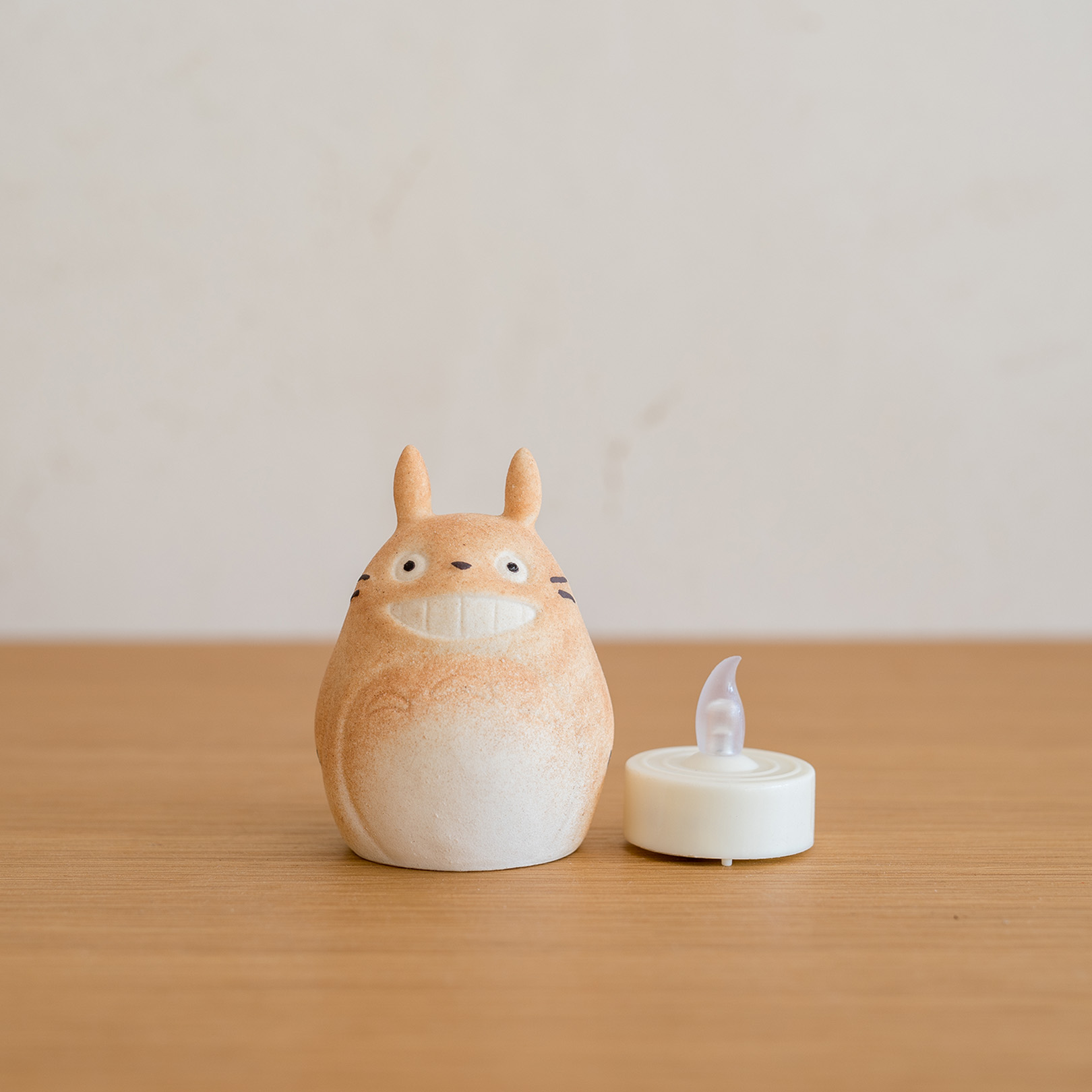 暗がりでLEDの灯りに照らされる信楽焼 トトロのあかり