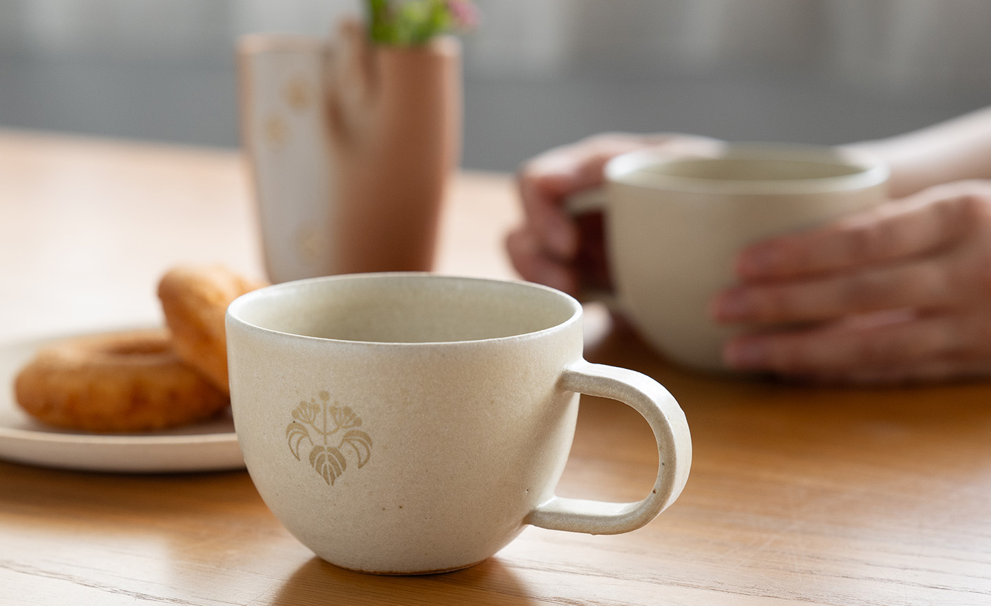 花個紋入りのマグカップでお茶をするシーン