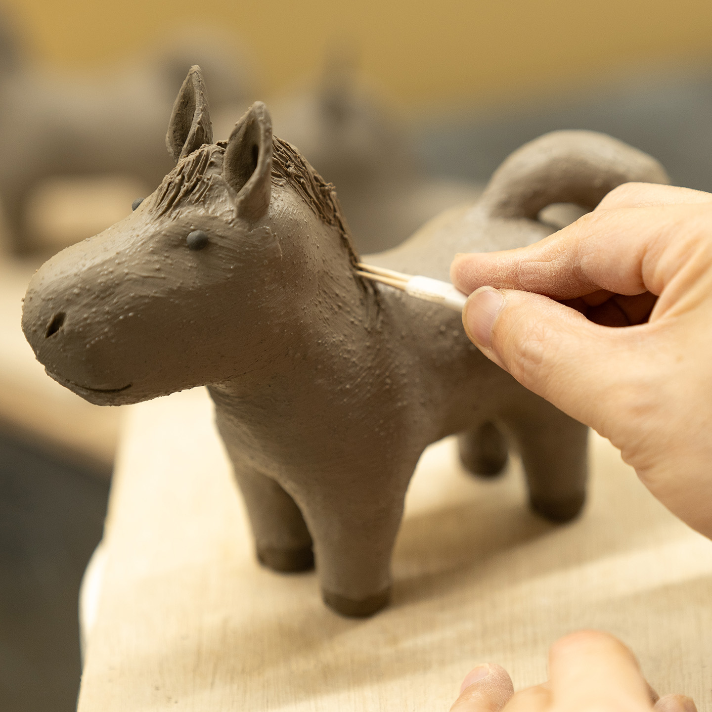 親午の立髪を専用の器具で描いている男性の手元