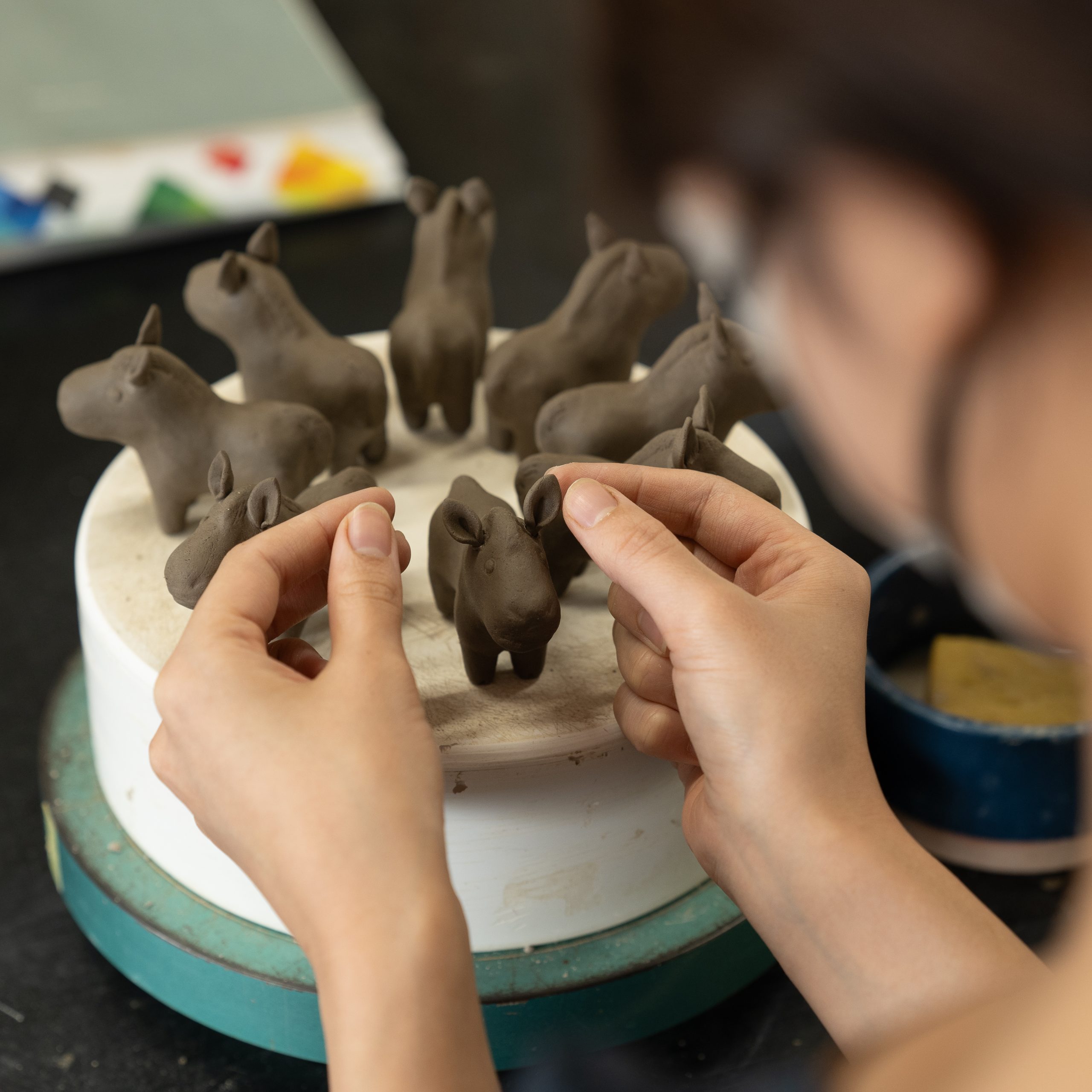 ピンと立った午の耳を取り付ける女性職人