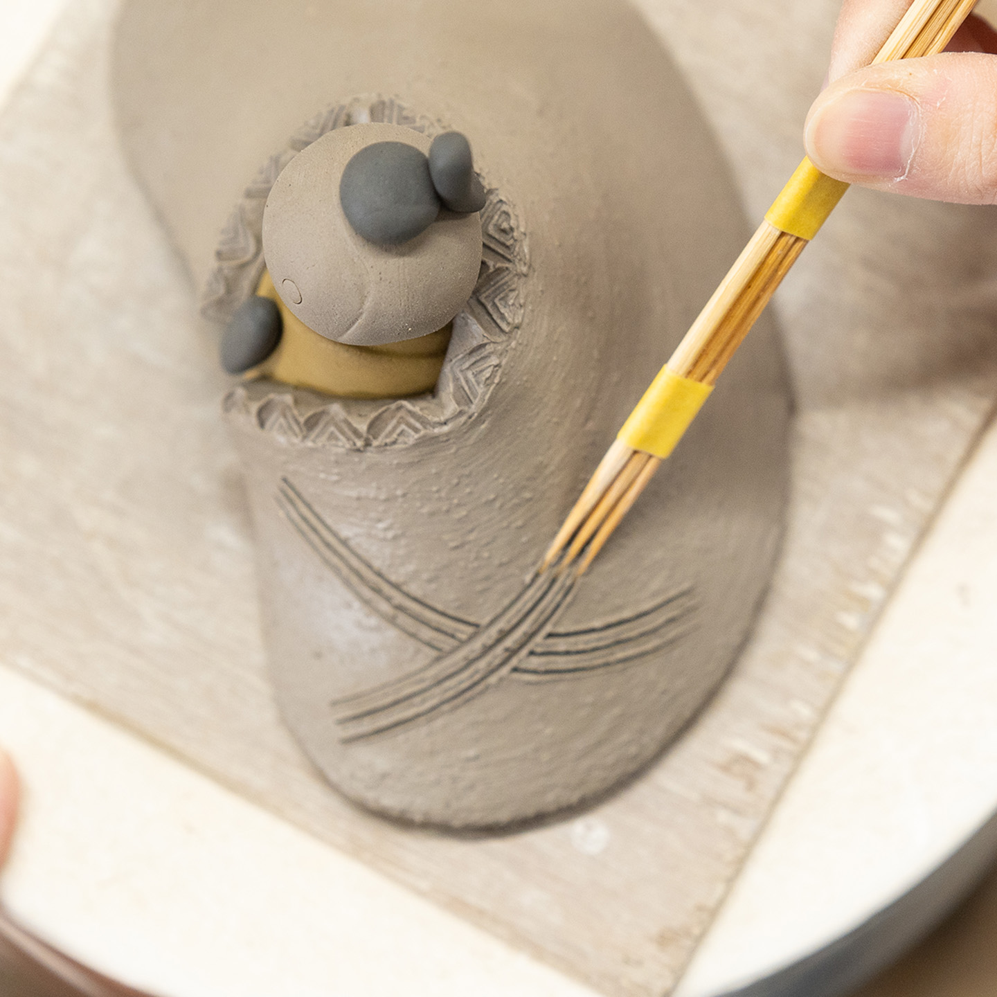 信楽焼の雛人形の着物に柄を施す職人の手元