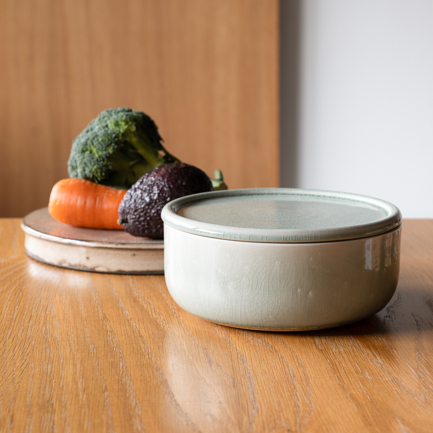 木のテーブルに置かれた浅型ぬか壺と野菜