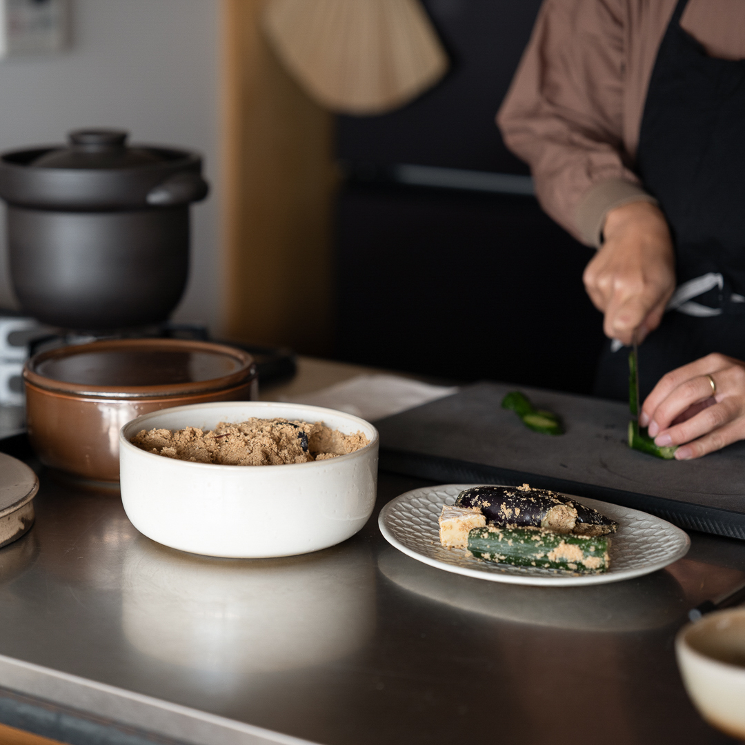 ぬか壺で漬けた野菜をカットする女性の手元