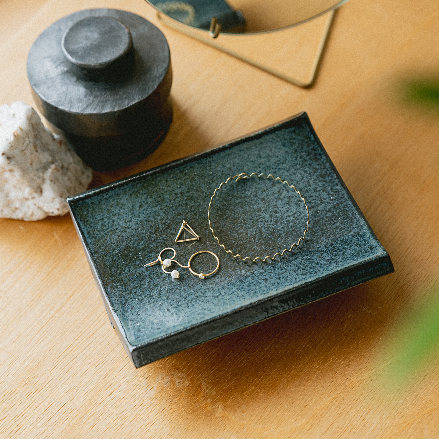 アクセサリーを置いた黒いアーチトレイ、インテリアになじむ信楽焼のトレイ