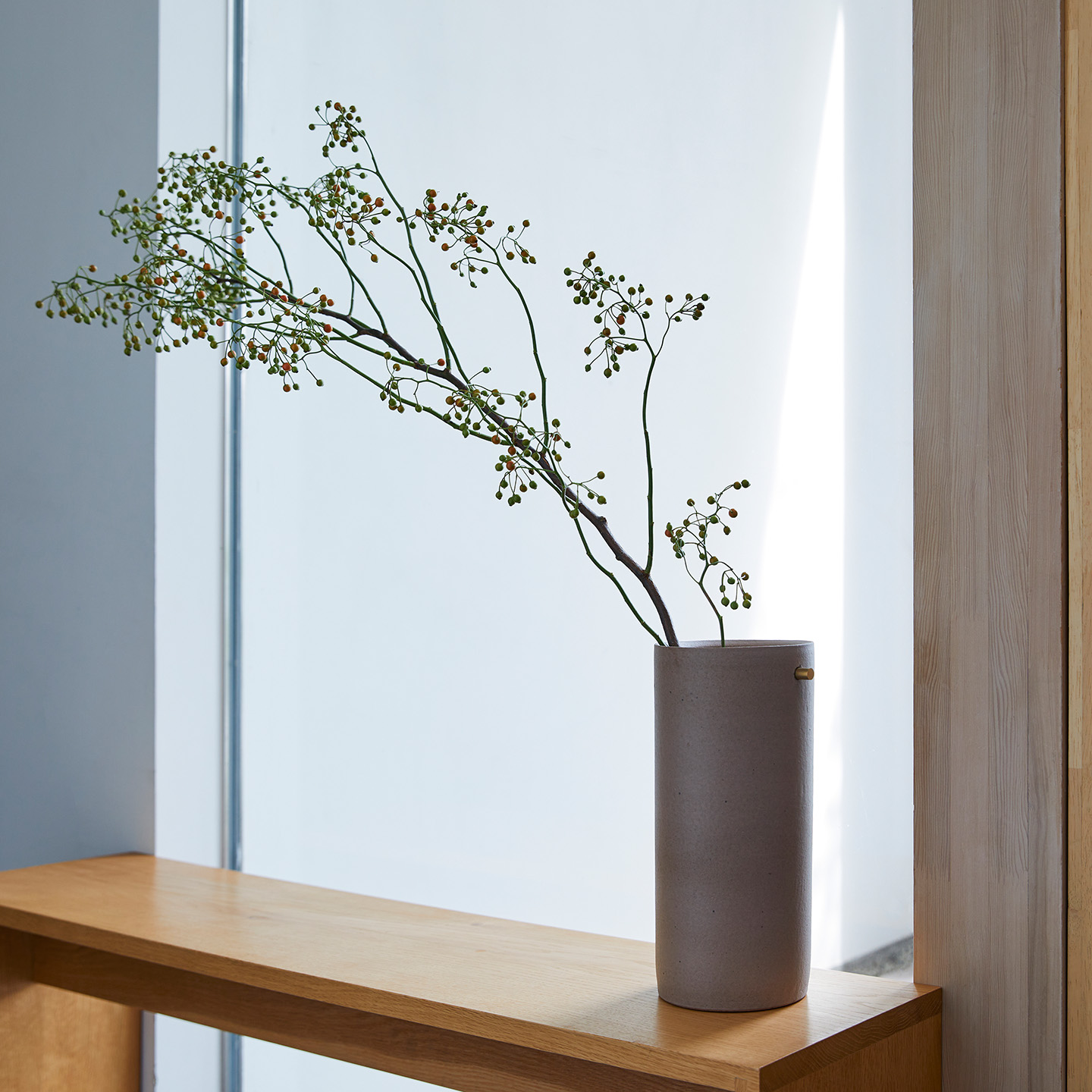 HIJICA TEOKE vase（L）に枝ものをのびやかに生けた、梅雨の季節の窓辺の花器