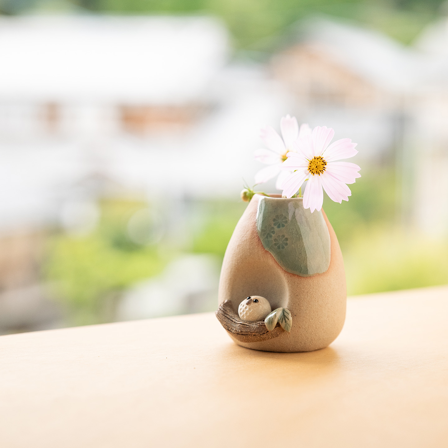 ふくろうのついた花器に淡いピンクの花を生けた、梅雨の季節に彩りを添える一輪挿し