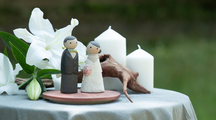白いユリとキャンドルを添えた信楽焼の洋装ウェディングドール